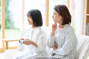 悩む母親・ゲームをする子供