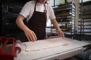 Close-up of baker preparing pastries in bakery.
