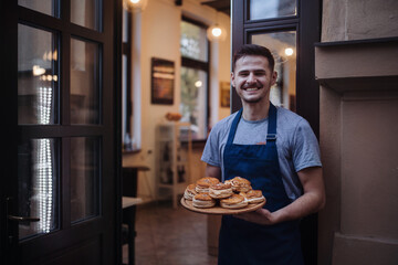 Fototapeta na wymiar Man with apron holding a fresh pastries.