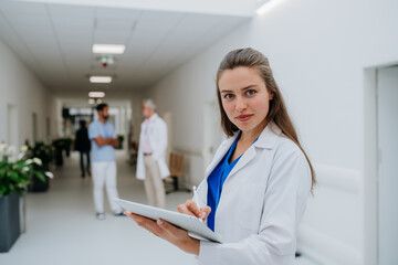 Portrait of young woman doctor at hospital corridor.