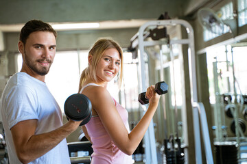 Fototapeta premium Sport man trainning woman exercise lifting weight in sport gym