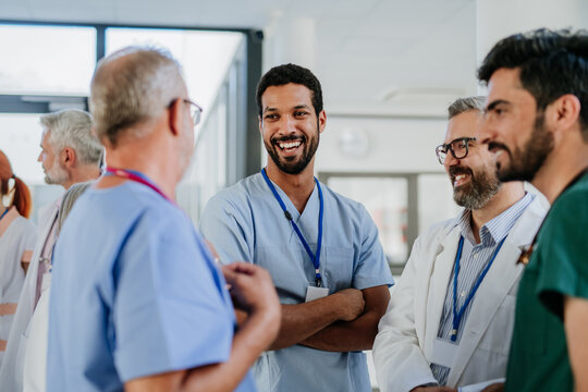 Team of doctors discussing something at hospital corridor.
