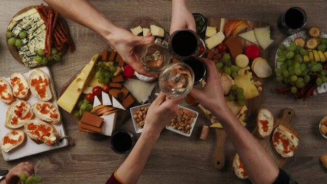Table with wine appetize and cheese plates, top view. Enjoying dinner with friends, drinking red and whitre wine.