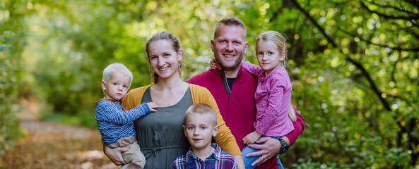 Portrait of happy family with kids in a forest.