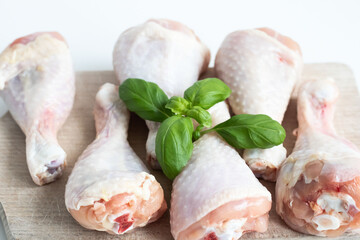 Raw chicken legs. On a white background. Salt, pepper, leaves