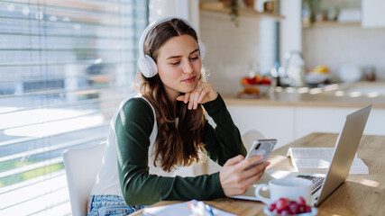 Young woman having distance education in her apartment.