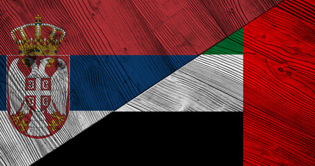 Background with flag of Serbia and United Arab Emirates on wooden divided table. 3d illustration