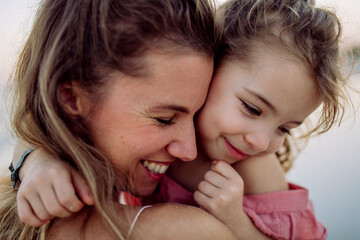 Portrait of mother and her little daughter, enjoying time at sea.