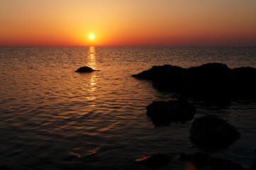Fototapeta na wymiar Beautiful landscape with colorful sunset on the sea rock beach.