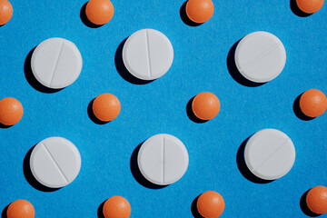 Medicine and drug concept. Pharmacy and health care background. Close up of different tablets pattern on blue.