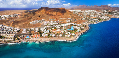 Naklejka premium Lanzarote island, Playa Blanca resort. aerial drone panoramic view with Red volcano. Flamingo becah Canary islands of Spain