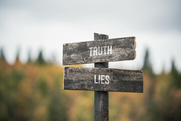 vintage and rustic wooden signpost with the weathered text quote truth lies, outdoors in nature....