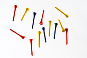 color wooden bamboo golf tees fallnig through the air isolated on a wooden background