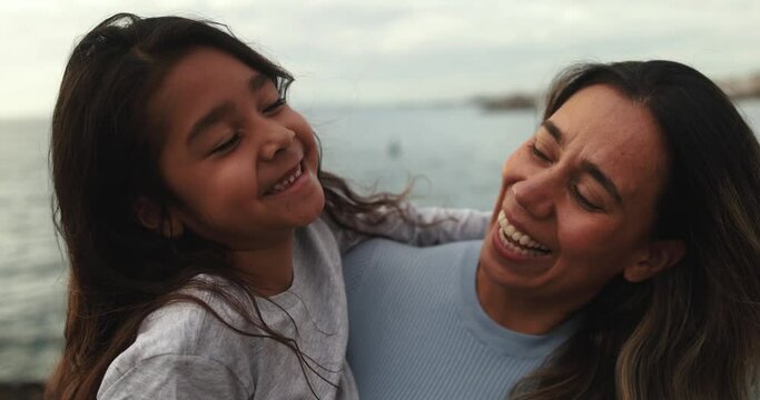 Happy latin mother and daughter having fun together outdoor while smiling on camera - Family love and lifestyle concept 