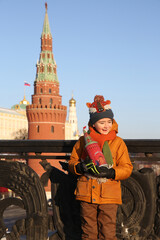 Russian tourist child, cute kid, boy on Red Square. Tower of Kremlin in Moscow city, Russia. Kremlin in Moscow, Russia. Moscow landmark, Russian monument. Moscow Kremlin. New Year, winter in Russia