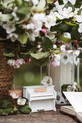 A beautiful postcard. A white piano, a statuette, candles, a book and a vase with a bouquet of...