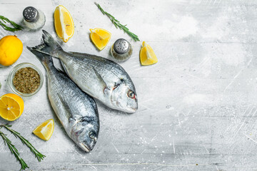 Raw sea fish with lemon wedges and garlic.