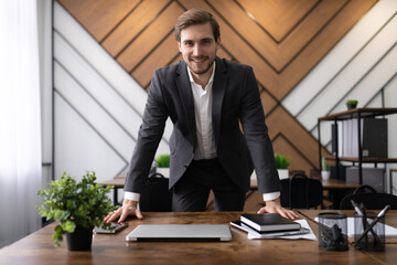 male businessman greets new employees in the office looking at the camera