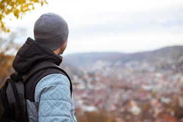 Fototapeta premium Young man sitting with his back looking at the panoramic view of the city