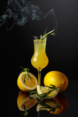 Traditional homemade lemon liqueur limoncello on a black background.