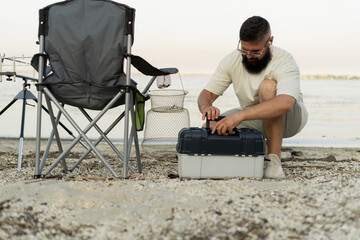 Fisherman with a large fisherman's tackle box. Fishing lures and accessories.