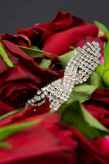 Women's diamond ornament in red rose flowers on black background.