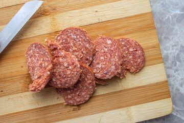 Top view of sliced sucuk on chopping board.