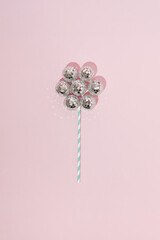 Shiny flower made with disco balls and paper straw. Minimal party concept. Flat lay. Top view.