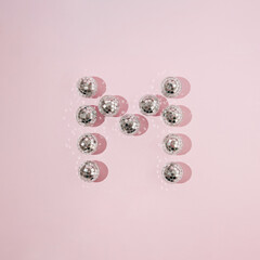 Letter M made with shiny disco balls. Minimal music or party concept.