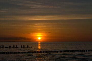 Sunset on the Baltic Sea. Sea, groyne strong colors. Vacation on the beach. Romantic