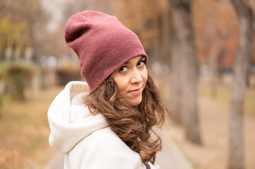 Portrait of a beautiful young woman in the park. A woman with long beautiful hair on a walk in the park.