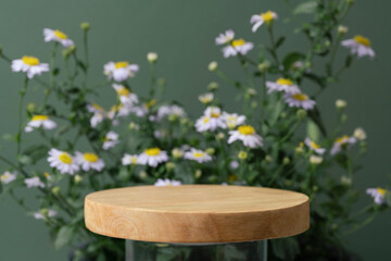 wood podium and white daisy flowers on green background with space.beauty cosmetic skin care...