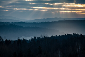 Sunrays over the mountains in the mist, Bieszczady, Poland