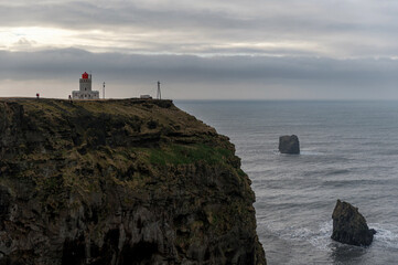 Fototapeta na wymiar Lighthouse near the Black Sand Beach Reynisfjara in Iceland. Morning Sky.