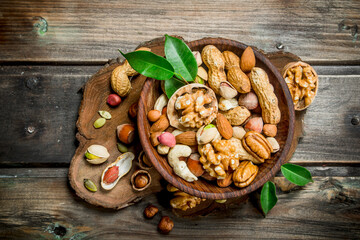 Different kinds of nuts in bowl with leaves.