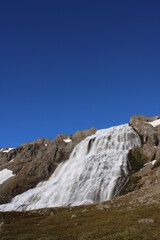 Dynjandi waterfall flowing over mountains into a fjord, Iceland