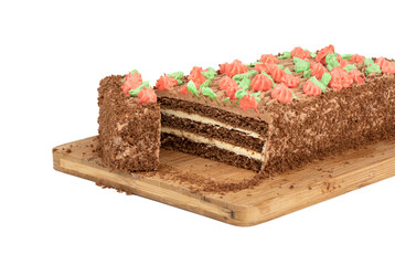 A cut piece from a biscuit cake decorated with multi-colored buttercream flowers.