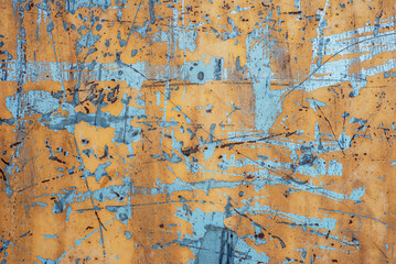 Abstract texture background of a painted yellow weathered, cracked and peeled concrete wall