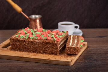 Selective focus on biscuit cake decorated with multicolor buttercream flowers.