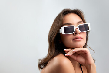 Naklejka premium Self-confidence. Young stylish beautiful girl in fashionable eyewear isolated over grey background. Concept of beauty, skin care, cosmetology, fashion