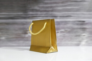 A golden gift bag with a wooden background