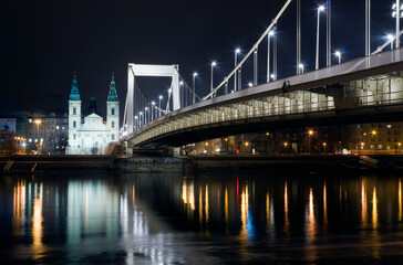 Fototapeta na wymiar The inner city parish church and Elizabeth Bridge in Budapest at night