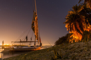 Night view of a felucca sail boat at the river Nile, Egypt - obrazy, fototapety, plakaty