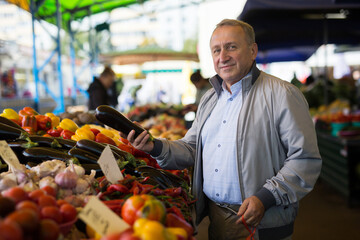 Man choosing vegetables in greengrocery