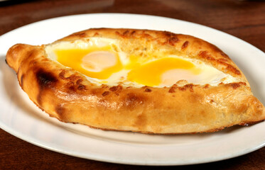 Khachapuri in Adjarian or Adjara khachapuri, boat, national Georgian cuisine, pastry with cheese and egg.Georgian cuisine.