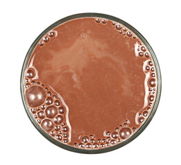 Chocolate milk puddle in glass isolated on white, top view