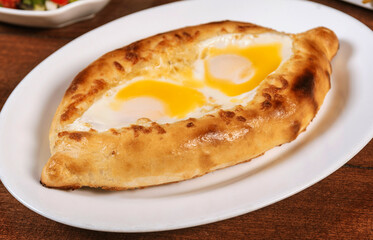 Khachapuri in Adjarian or Adjara khachapuri, boat, national Georgian cuisine, pastry with cheese and egg.Georgian cuisine.