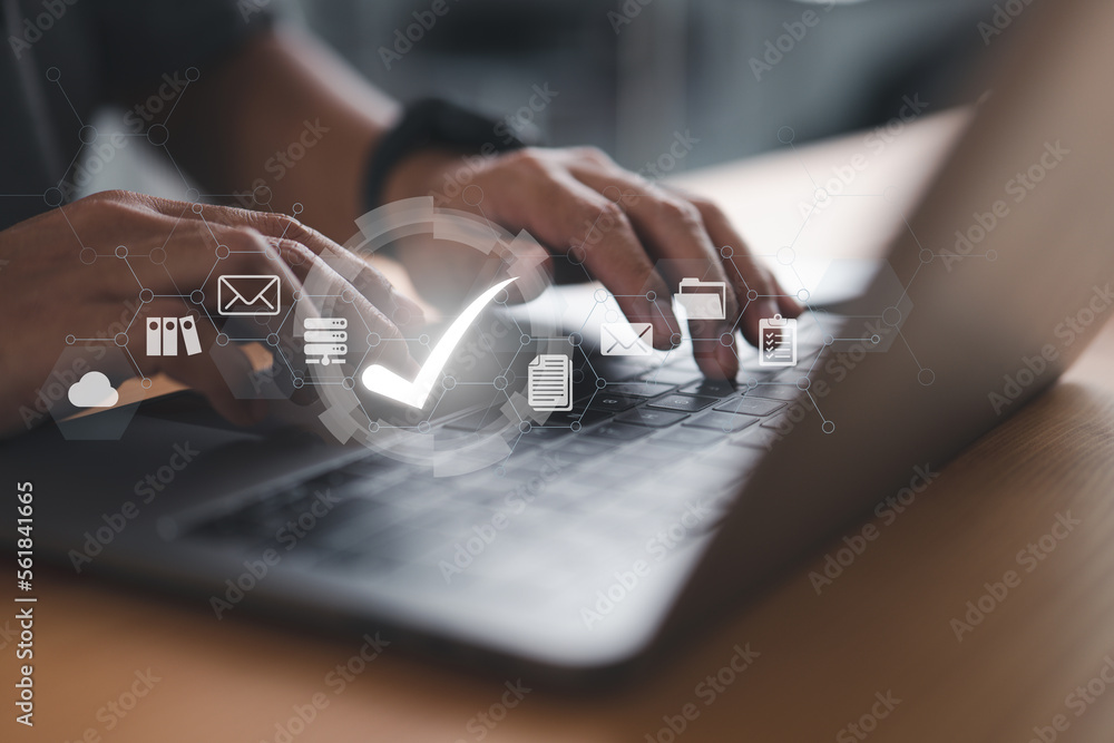 Poster A businessman is using a laptop with a virtual document and a correct sign for online approval of the paperless and quality assurance concept.