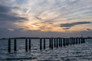 Obraz premium wooden groynes in the sea at Bosham West Sussex England at sunset