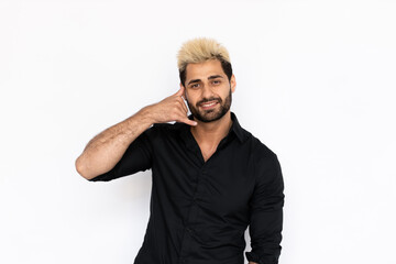 Winsome young man making phone gesture. Male Caucasian model with brown eyes, ombre painted hair and beard in black shirt smiling showing call me back sign. Coquetry, advertisement concept